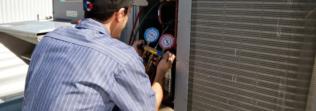 HVAC technician servicing a condenser unit in Bolivar